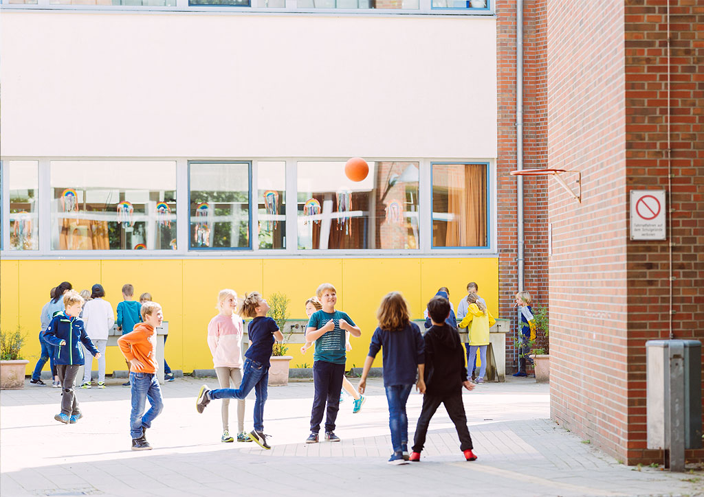 Das Bild zeigt spielende Kinder auf dem Schulhof der Schule Lehmkuhle.