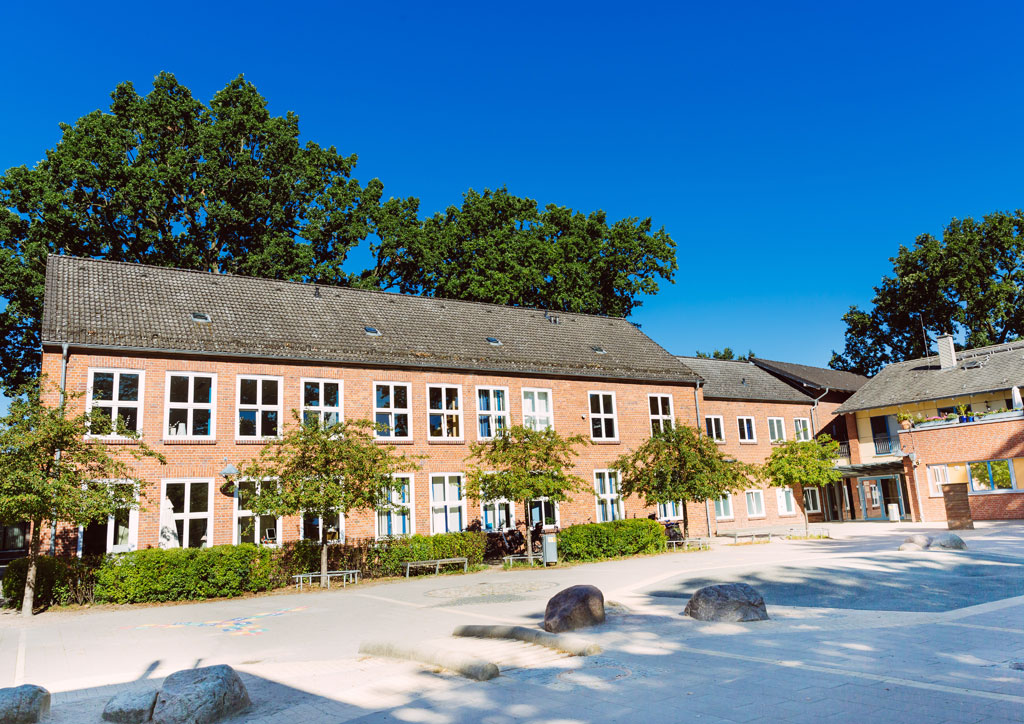 Das Bild zeigt den Schulhof der Schule Lehmkuhle. Hier werden in den Pausen Fahrzeuge raus geholt mit denen die Kinder fahren dürfen.