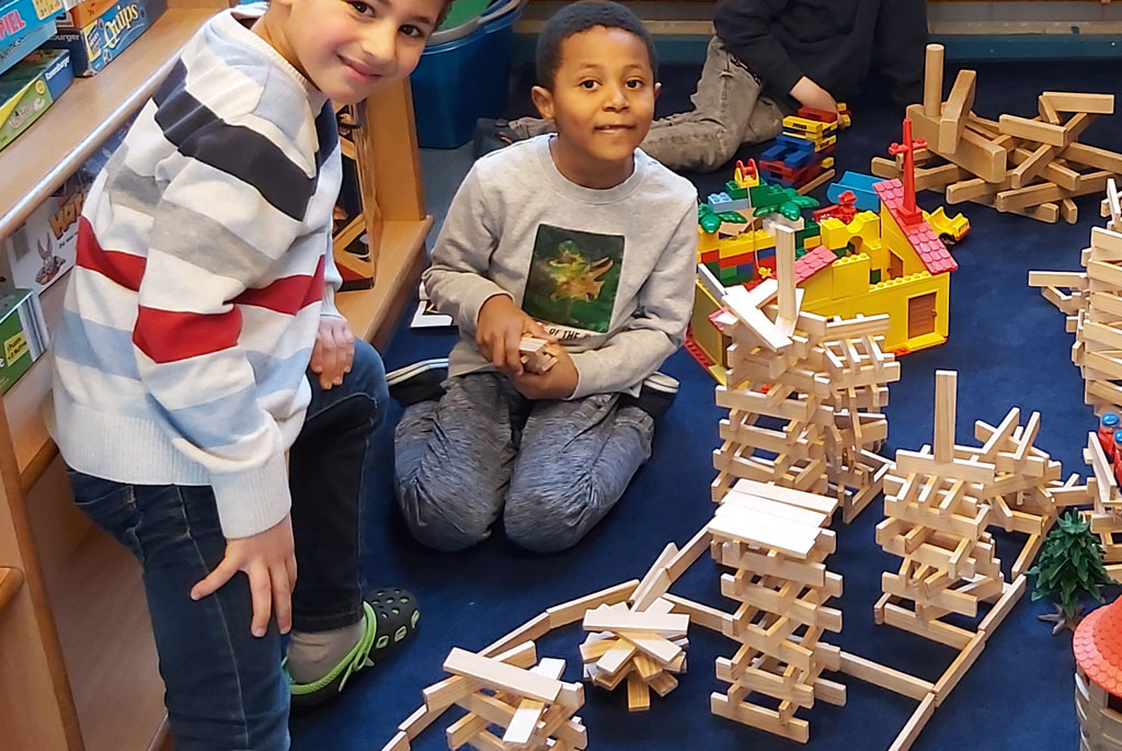 Eiige Vorschüler bauen mit Kapla Steinen